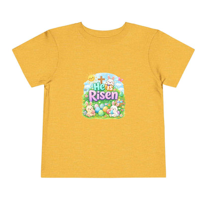 He Is Risen toddler tee with Easter bunny, cross, and pastel eggs design for kids