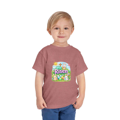 Toddler wearing He Is Risen Tee with Easter bunny and cross design on pastel shirt