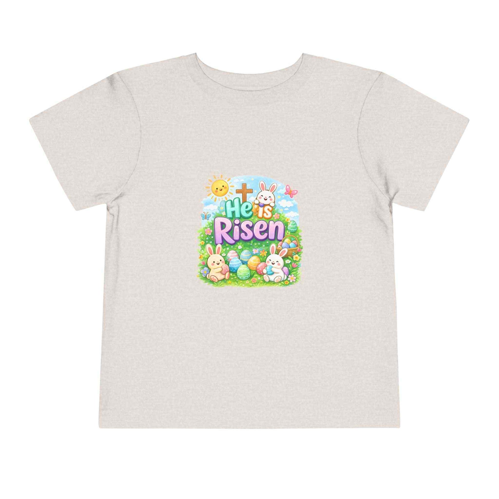 He Is Risen toddler tee with Easter bunny, cross, and pastel eggs design for kids