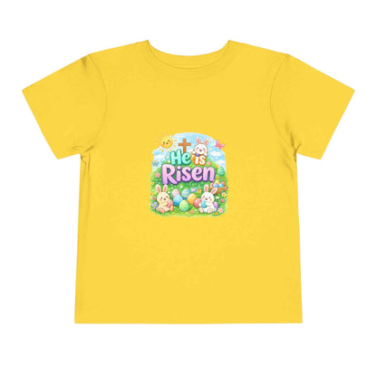 He Is Risen toddler tee with Easter bunny, cross, and pastel eggs design for kids
