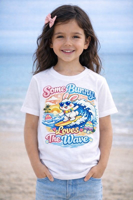 Youth girl Easter T-shirt with surfing bunny and pastel eggs, "Some Bunny Loves The Wave" design