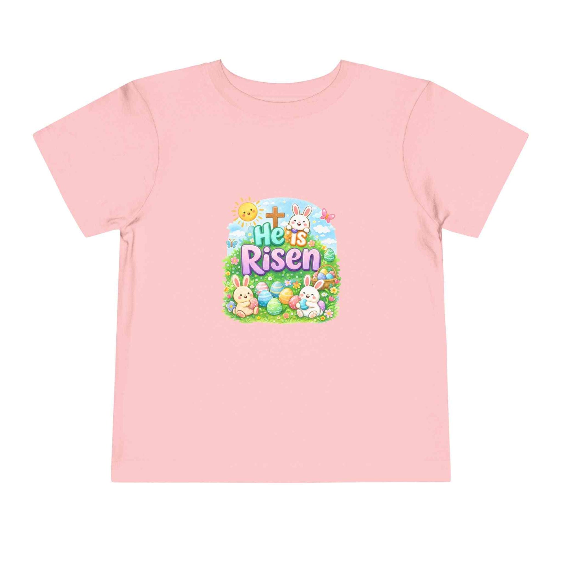 He Is Risen toddler tee with Easter bunny, cross, and eggs in pastel colors on soft cotton shirt