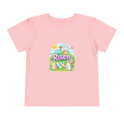 He Is Risen toddler tee with Easter bunny, cross, and eggs in pastel colors on soft cotton shirt