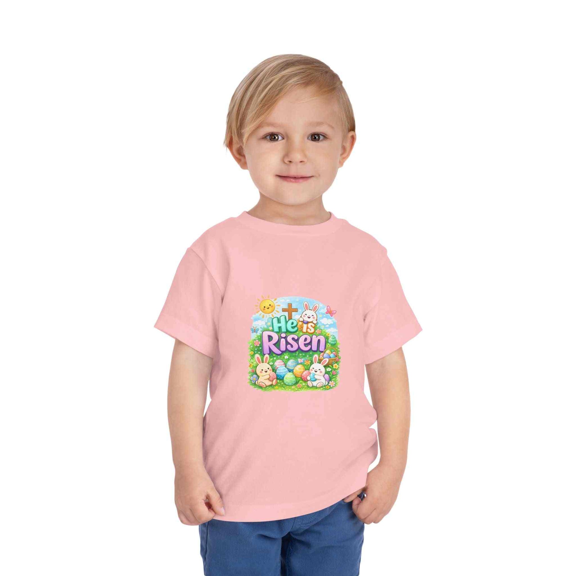 He Is Risen toddler tee with Easter bunny, cross, and pastel eggs design on soft, lightweight fabric