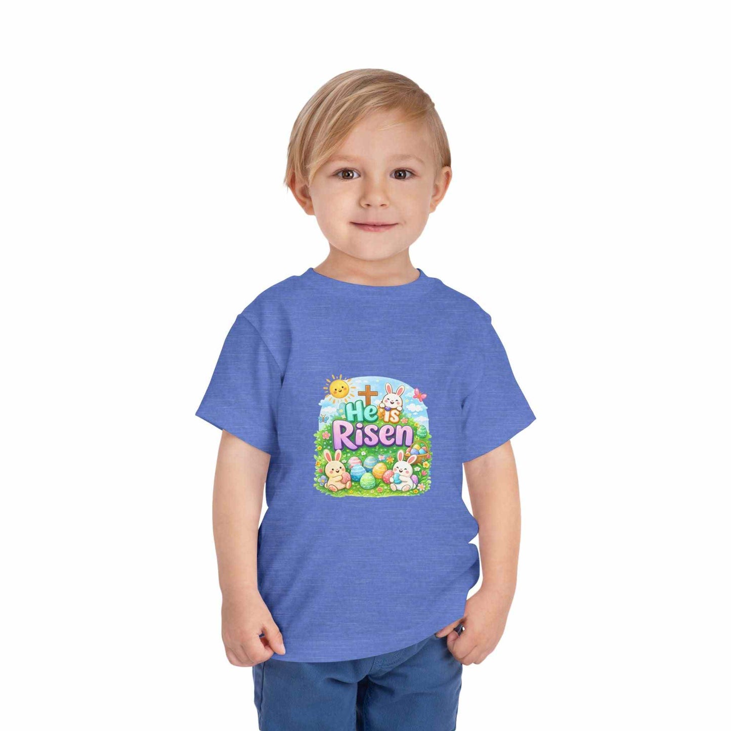 He Is Risen toddler tee with Easter bunny, cross, and pastel eggs design on soft cotton shirt for kids