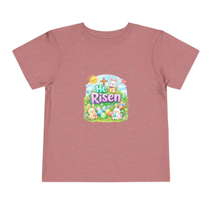 He Is Risen toddler tee with Easter bunny, cross, and pastel eggs design on soft cotton kids shirt