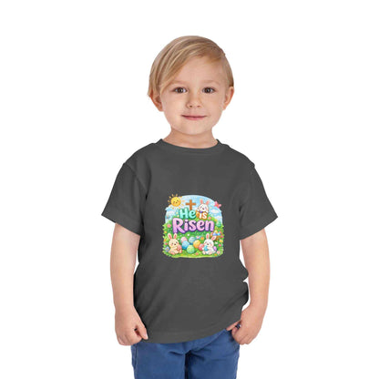 He Is Risen toddler tee with Easter bunny, cross, and pastel eggs design on soft cotton kids shirt