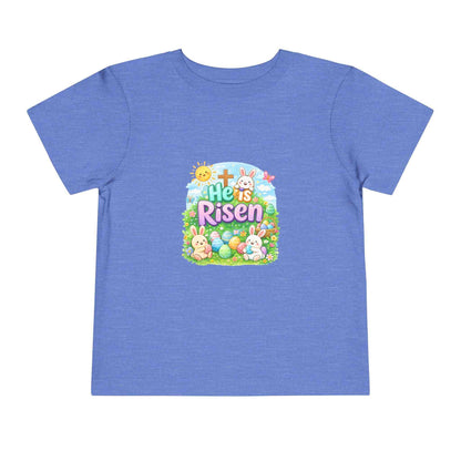 He Is Risen toddler tee with Easter bunny, cross, and pastel eggs design for kids